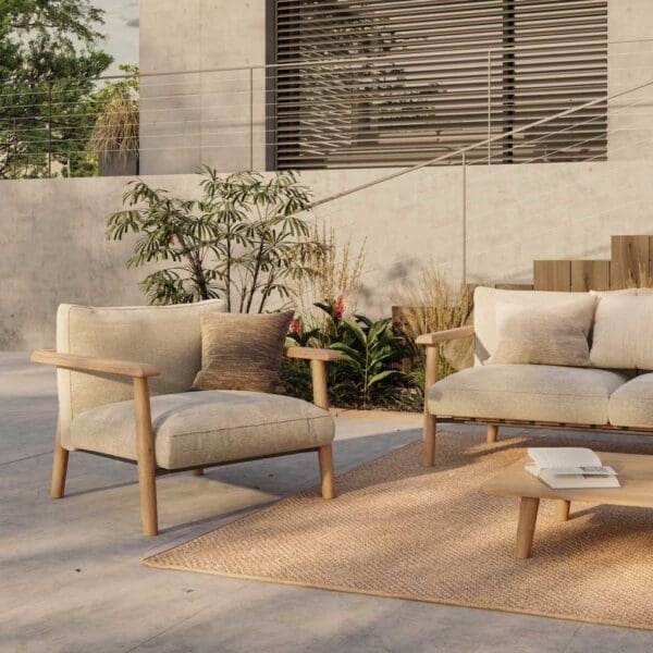 Image of Royal Botania Mambo contemporary teak garden armchair with modern concrete architecture in the background