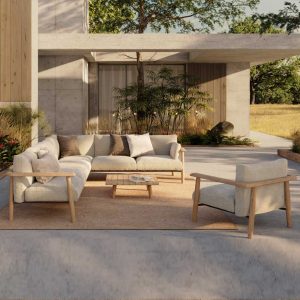 Image of Royal Botania Mambo Lounge modern teak corner sofa with beige cushions on sleek poured concrete terrace, with minimalist house in the background