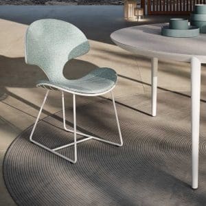 Image of Ostrea modern white garden chair next to Styletto round ceramic dining table by Royal Botania