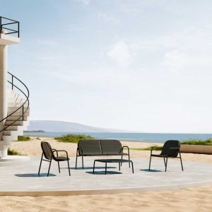 Image of Oiside Park stacking outdoor sofa and lounge chair on sunny terrace with blue sea and sky in the background