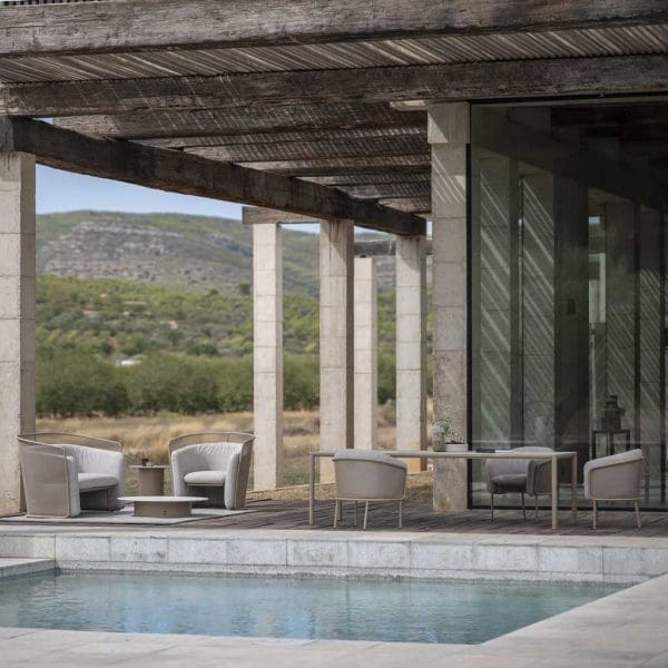 Image of Slide taupe modern garden furniture beneath split-cane pergola with swimming pool in the foreground