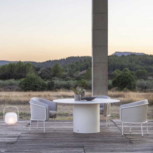 Image of pair of Slide modern white garden chairs, Branta round garden table and Otus lantern by Todus, on terrace at sunset