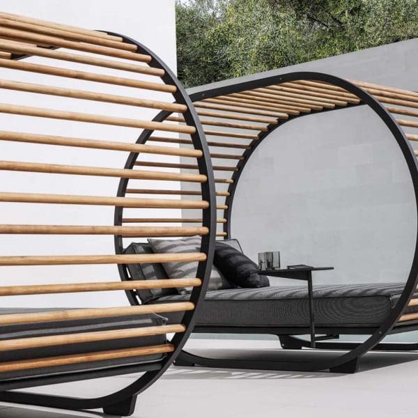 Image of pair of Gloster Cradle Lounge modern cabana daybeds with grey cushions on sleek terrace