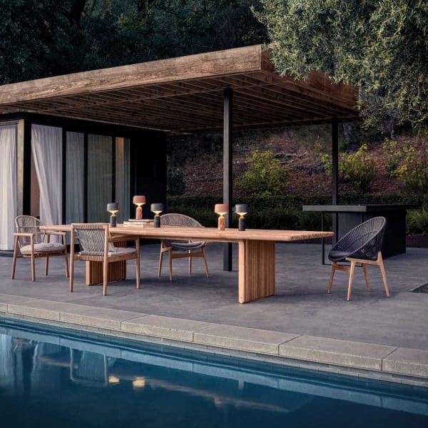Image of Gloster Deck minimalist garden table with range of dining chairs in poolside