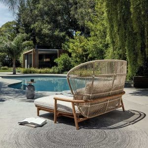 Image of Gloster Fern twin garden daybed and Blow side table by Gloster on sunny poolside with trees in the background