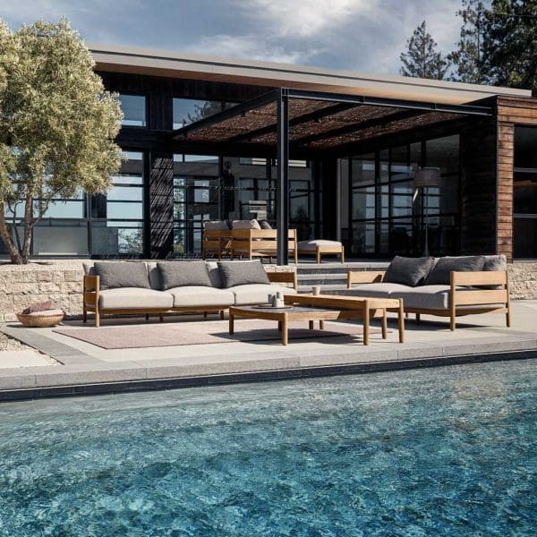 Image of Gloster Haven teak outdoor sofas on tiered terraces, with swimming pool in the foreground