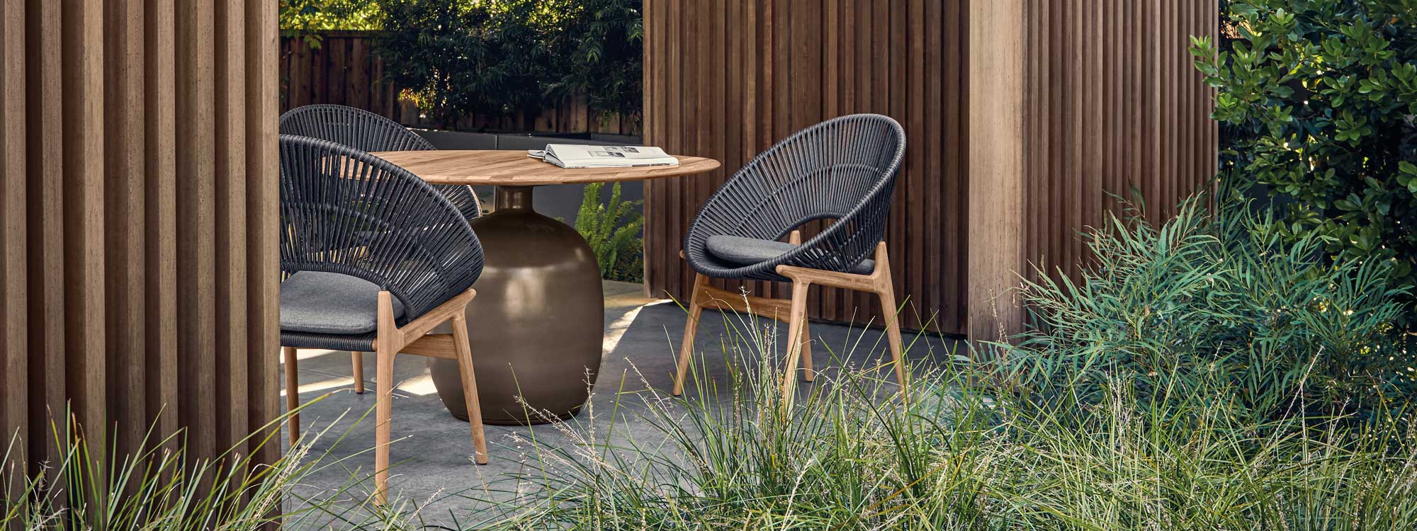Image of Kasha garden table with bulbous glazed ceramic base and teak top with Bora garden chairs by Gloster