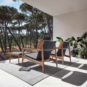 Image of pair of Gloster Archi minimalist teak lounge chairs on sunny terrace with Blow contemporary side table