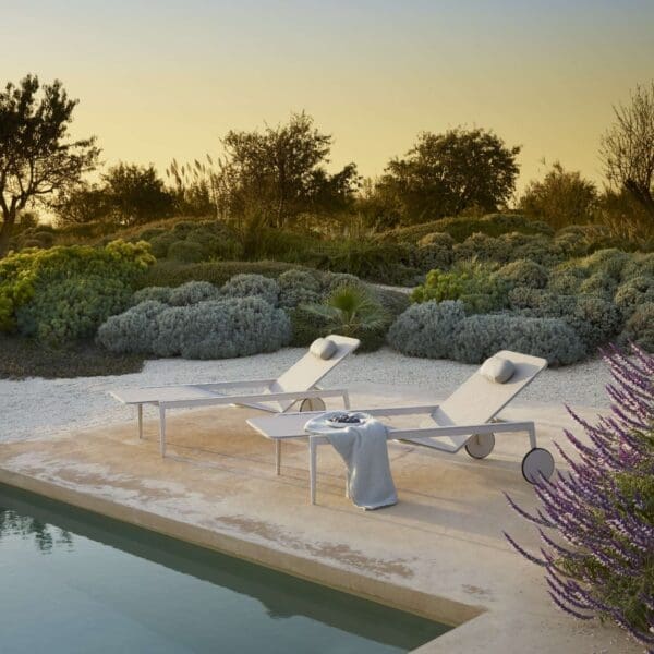 Image of pair of Royal Botania Styletto sun loungers at dusk around poolside