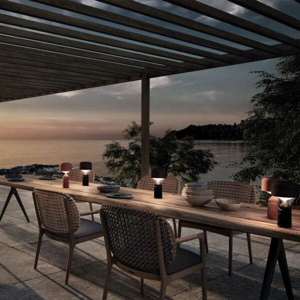 Image of Pebble minimalist garden table lamps on Gloster Raw garden table at dusk