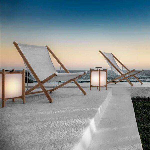 Image of lit Ambient Lanterns at dusk in between Gloster garden chairs