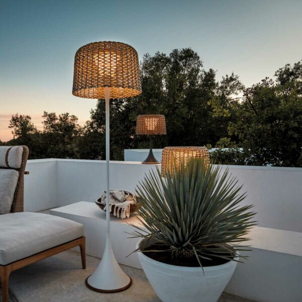Image of Ambient Mesh outdoor floor lights next to Gloster Fern furniture on white-washed terrace at dusk