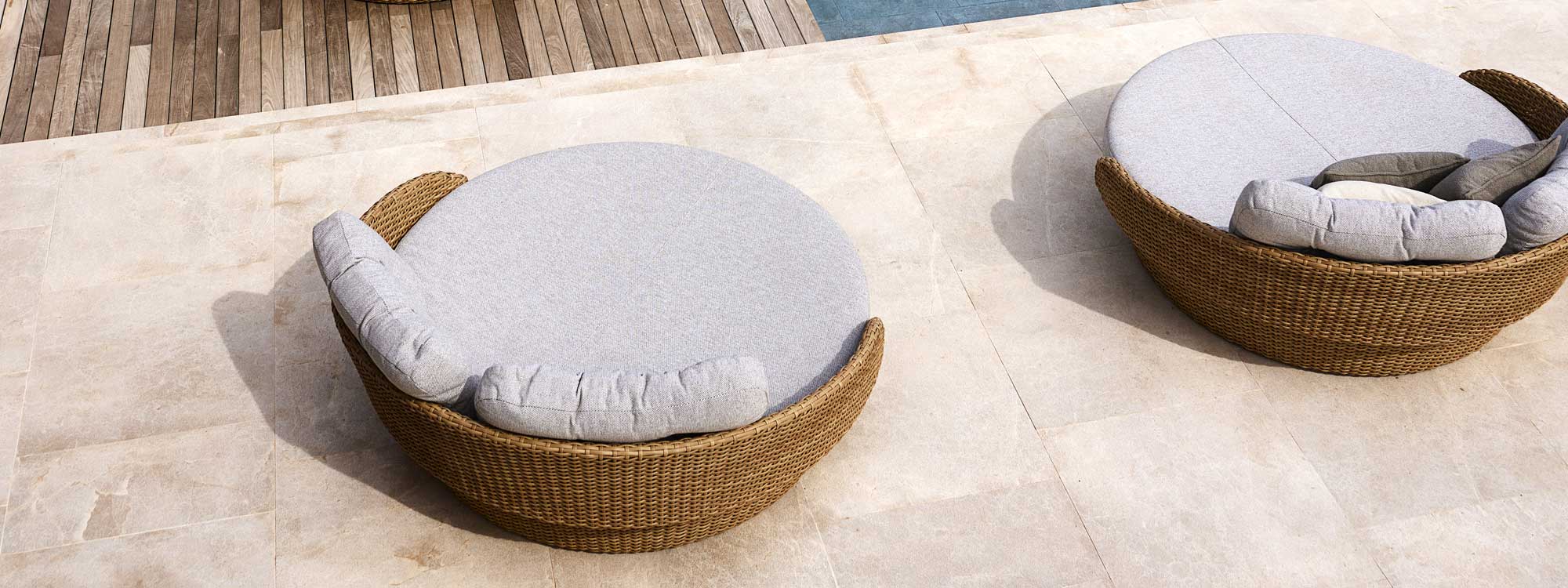 Image of pair of Cane-line Ocean Large round garden daybeds in natural Cane-line Flat Weave with White-Brown Cane-line Link fabric cushions