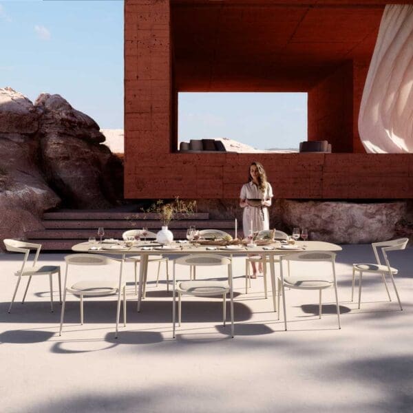 Image shows Royal Botania Styletto Garden Dining Set with a woman bringing over a serving bowl
