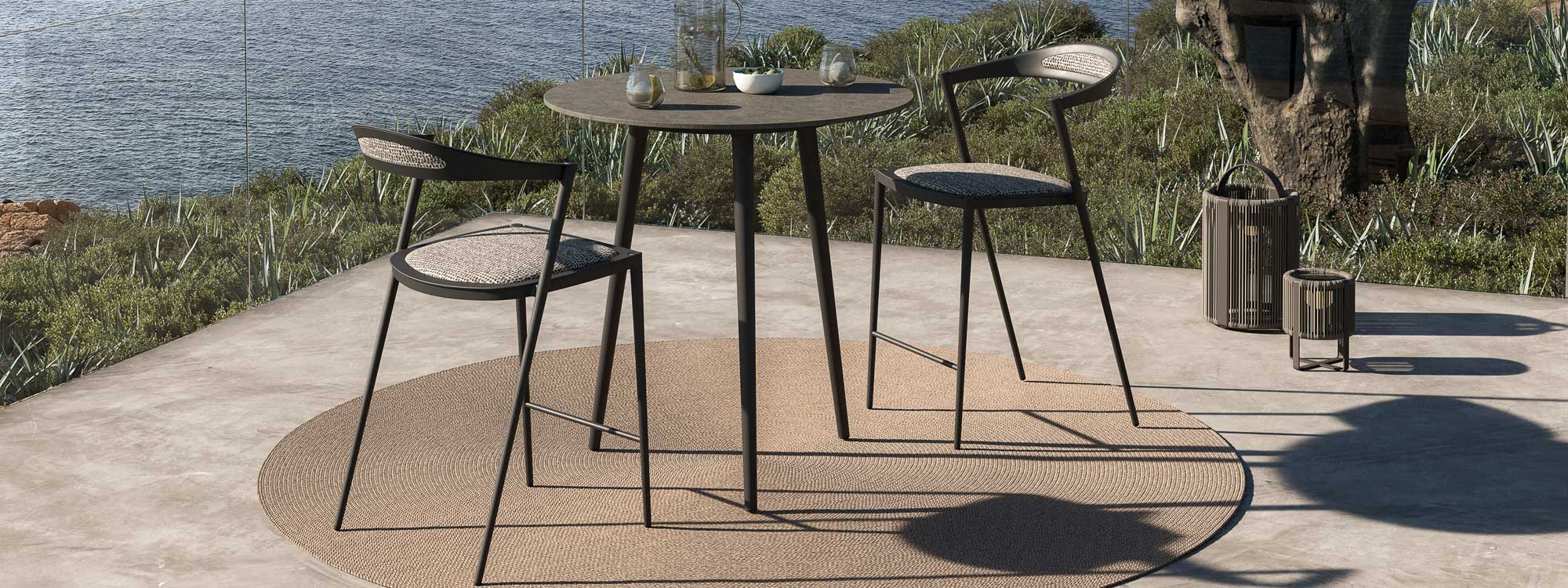 Image of Royal Botania Styletto high bar table and bar stools on sunny terrace overlooking the sea