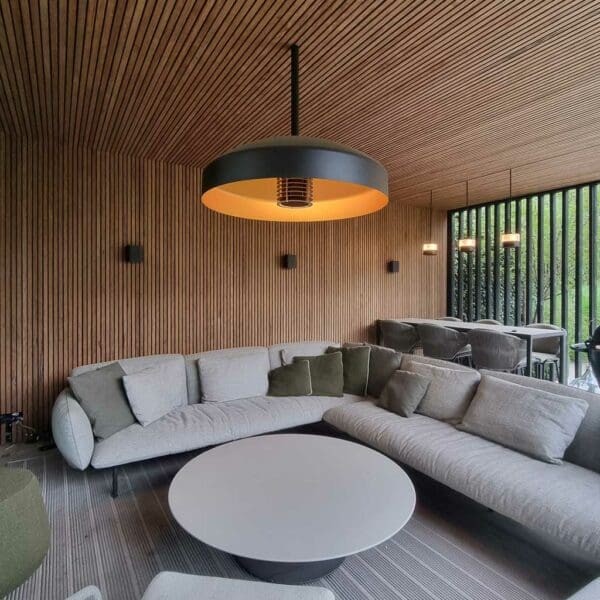 Image of Heatsail Disc Pendant electric ceiling heater in chic garden room above modern outdoor sofa
