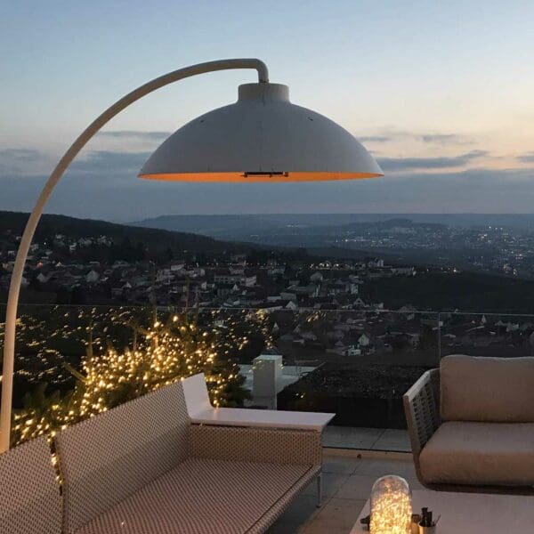 Image of Heatsail Dome electric outdoor heater on rooftop terrace at dusk, with city and hills in the background