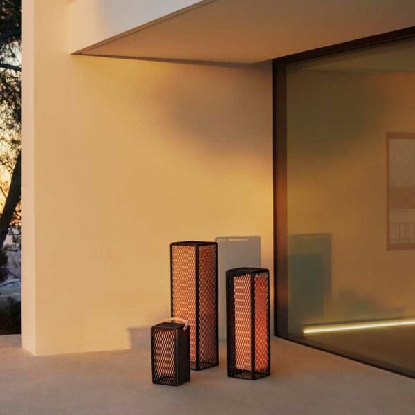 Image of 3 different sizes of Vondom The Factory modern garden lanterns on terrace at dusk