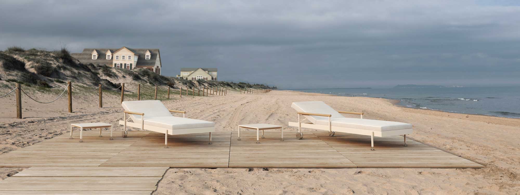 Image of pair of Vondom Hamptons contemporary sun loungers on wooden decking on the beach