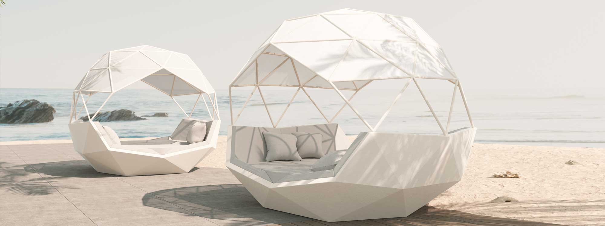 Image of pair of white Iglu twin daybeds by Vondom, shown on terrace with sea and rocks in the background