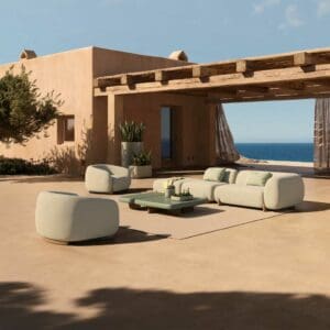 Image of Vondom Milos contemporary outdoor sofa and lounge chairs on sunny courtyard terrace with blue sea in the background