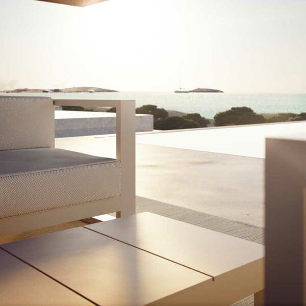 Image of detail of Posidonia modern garden lounge furniture and low table by Vondom with horizon swimming pool and the sea in the background