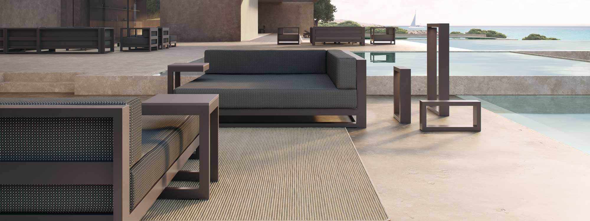 Image of Posidonia architectural garden sofas by Vondom on a minimalist coastal terrace