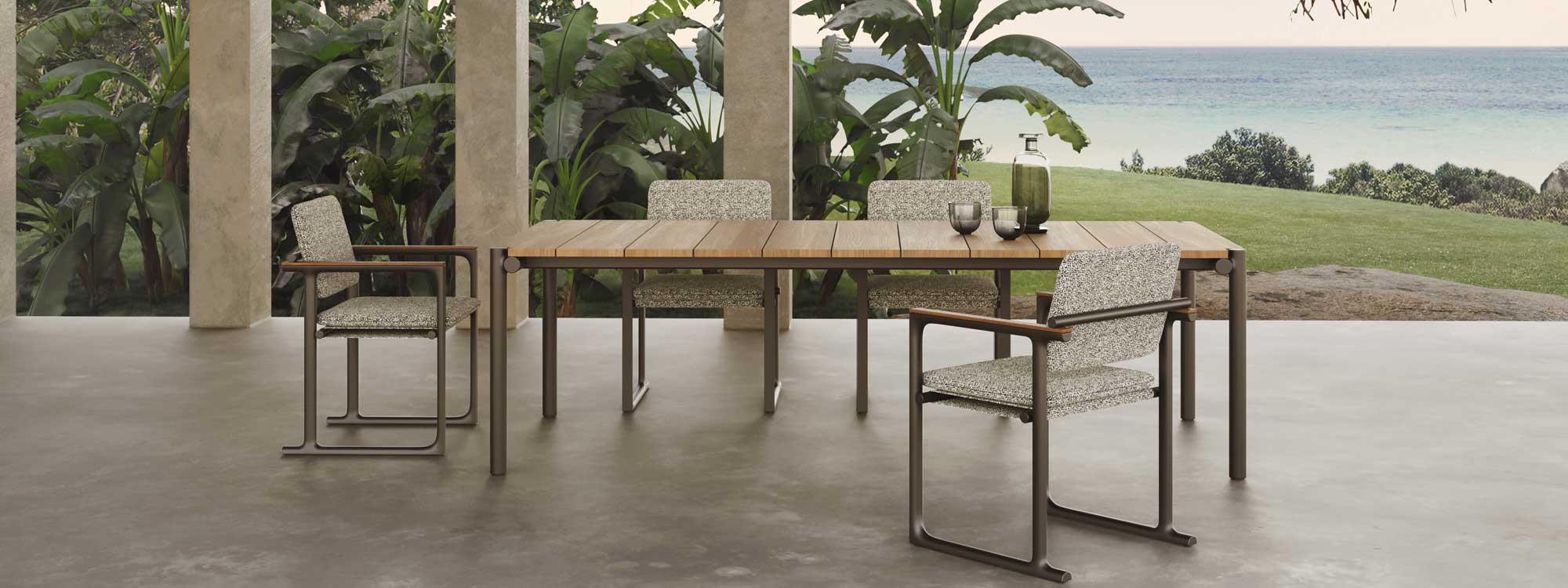 Image of Vondom Tulum modern garden dining set on terrace with banana plants, lawn and sea in the background