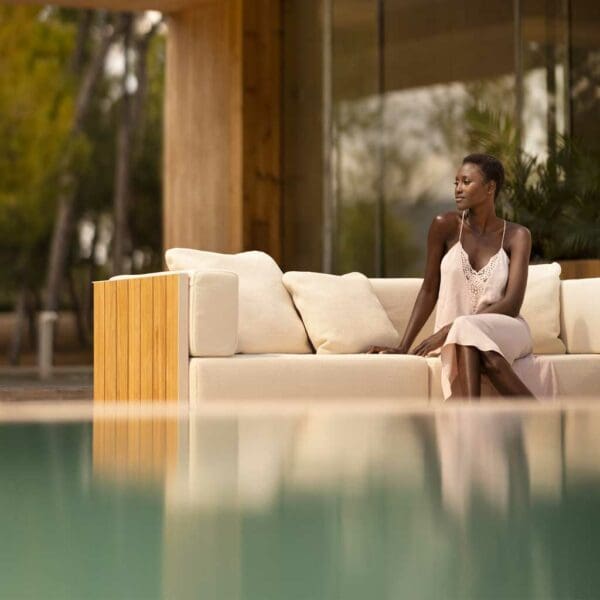 Image of woman sat in Vondom Vineyard contemporary garden sofa, with water of swimming pool in the foreground