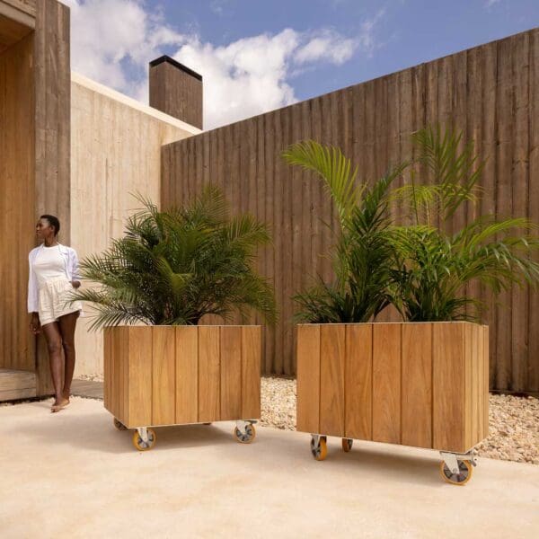 Image of elegant woman dressed in white stood next to pair of Vineyard planters with wheels by Vondom