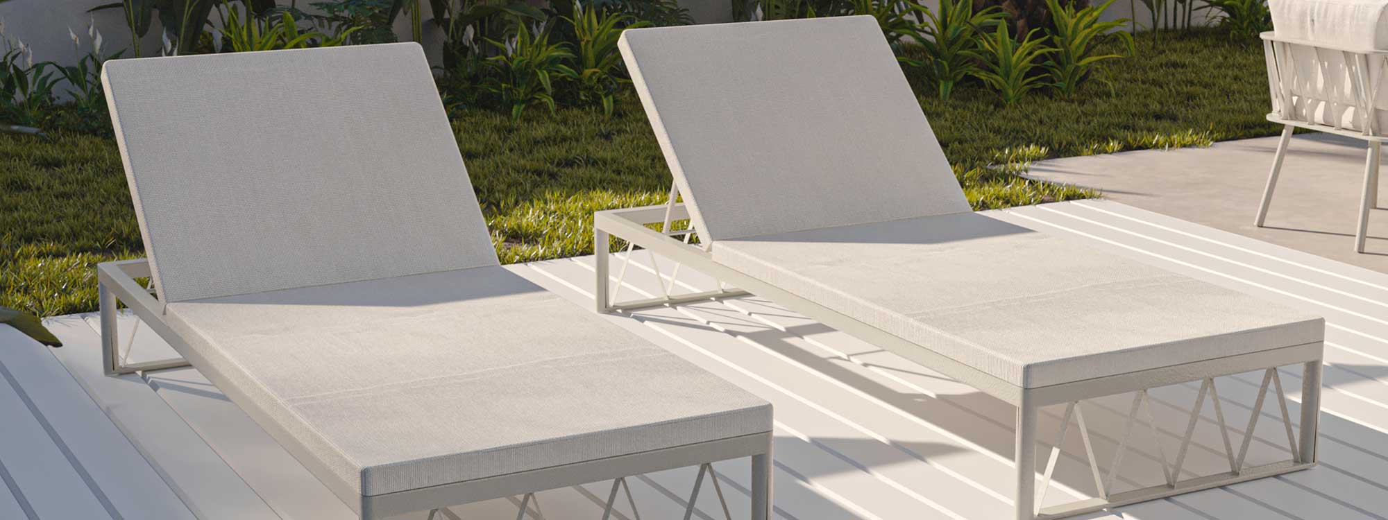 Image of pair of Oiside Ava white sun loungers on white decking in the sun