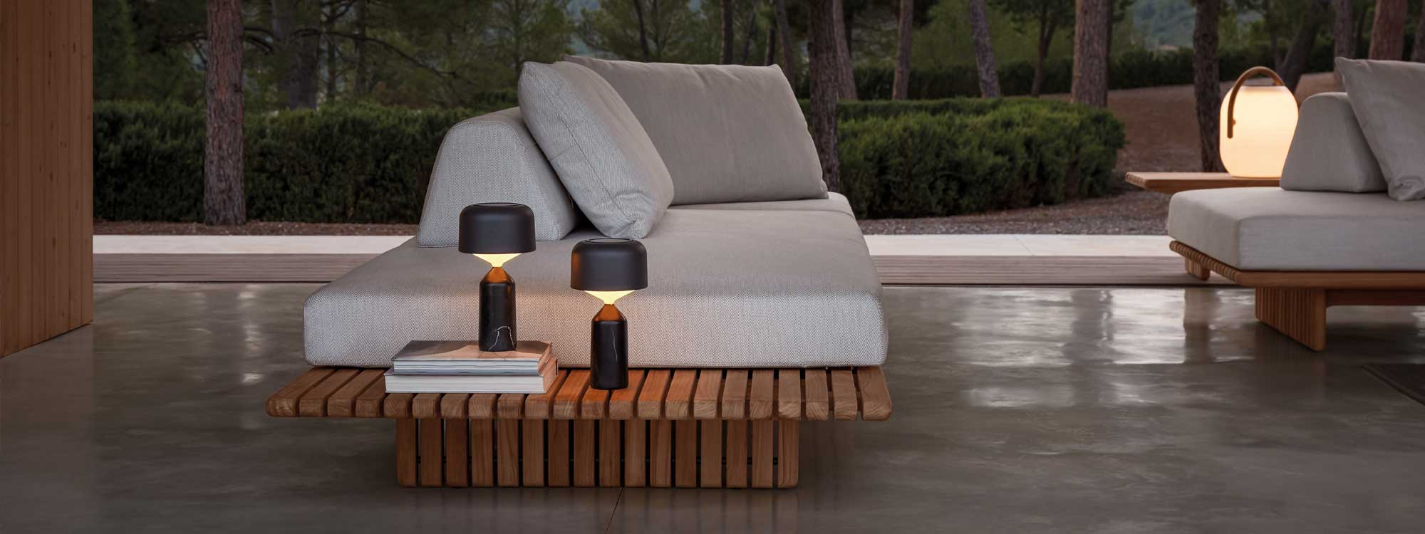 Image of Deck minimalist teak garden sofa and Pebble outdoor lights by Gloster