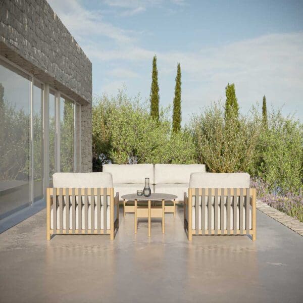 Image of Oiside Natura minimalist wooden garden sofa and lounge chairs on terrace, with trees & blue sky in the background