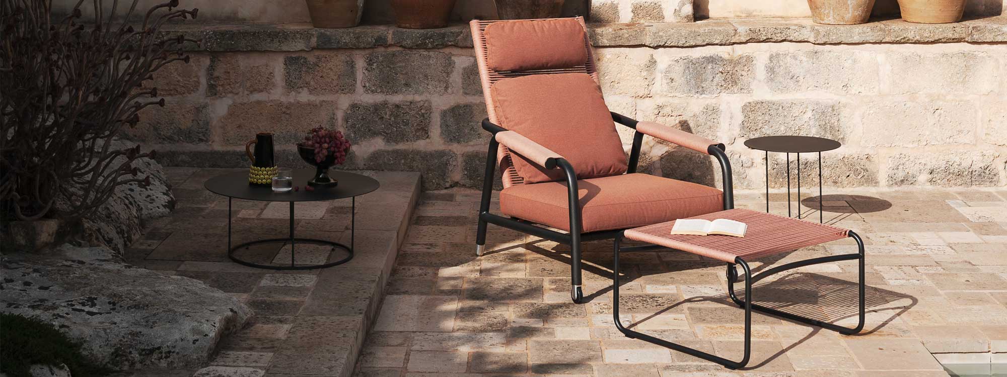 Image of Astra high-backed garden recliner and Harp foot stool in dappled sunlight on terrace
