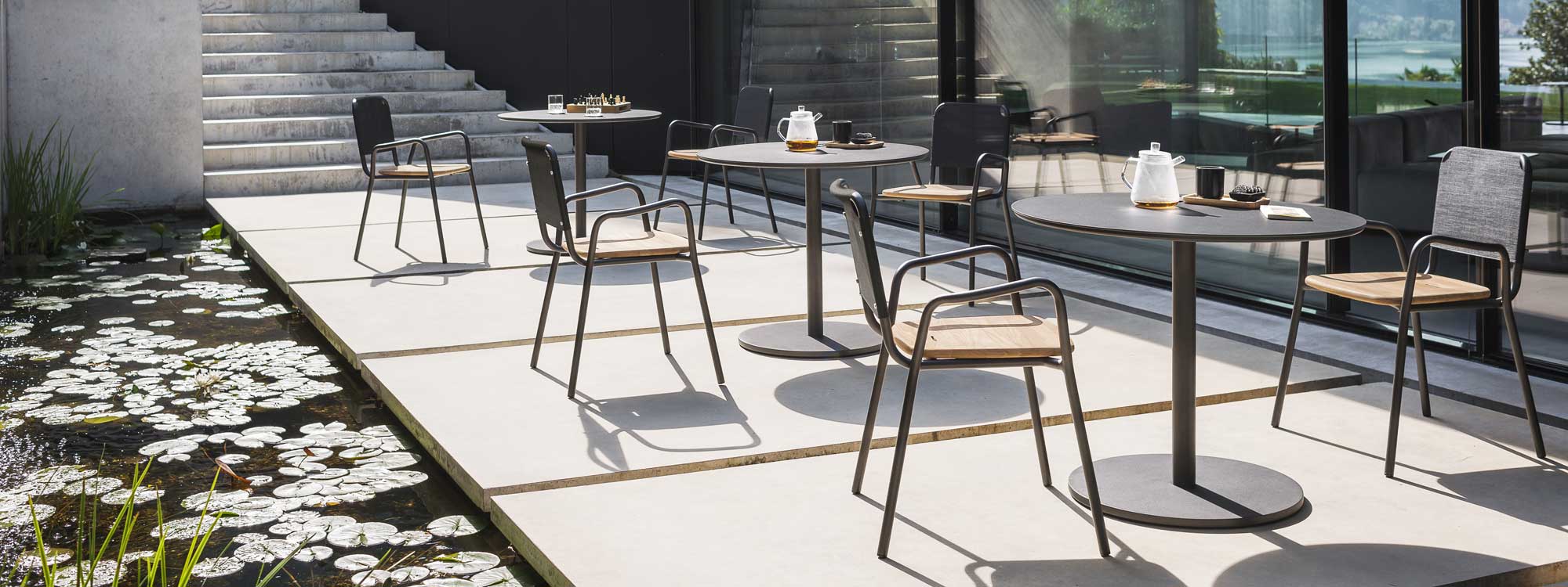 Image of Button modern bistro tables and Piper stacking armchairs by RODA