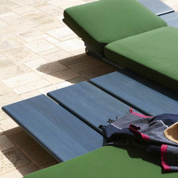 Image of blue Eolie low table next to green sun lounger cushions by RODA
