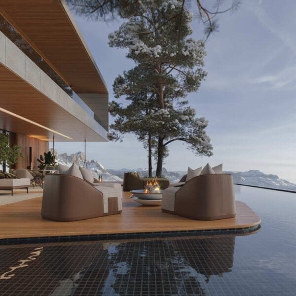 Image of Flow garden lounge chairs on poolside, with snow covered tree and mountains in the background