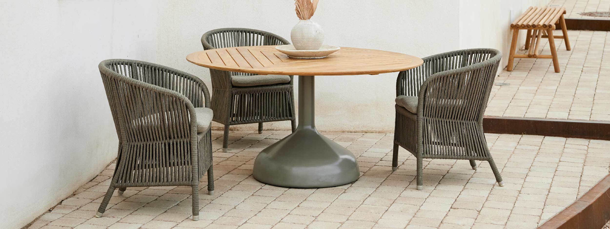 Image of Cane-line Derby garden armchair and Glaze circular dining table with teak top