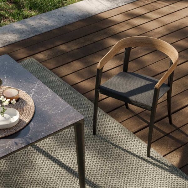 Image of detail of corner of U-nite luxury garden table shown next to Jive chair by Royal Botania