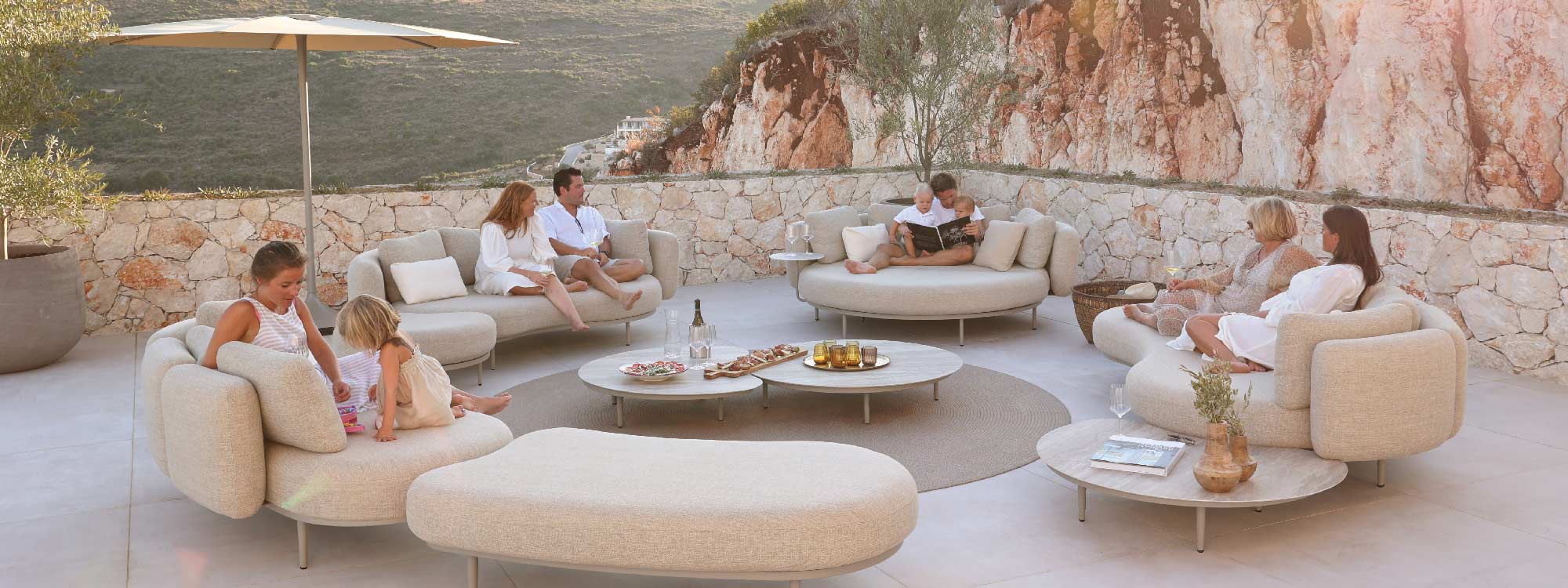 Image of family and friends sat relaxing on multiple Organix garden sofas by Royal Botania