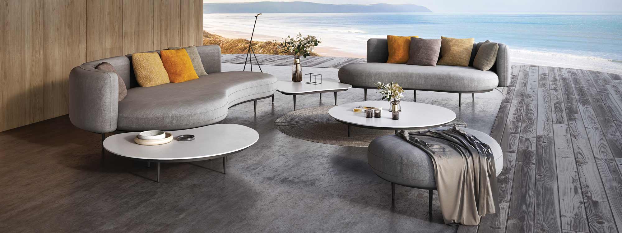 Image of Royal Botania Organix contemporary garden sofas on poured concrete floor, with beach and sea in the background