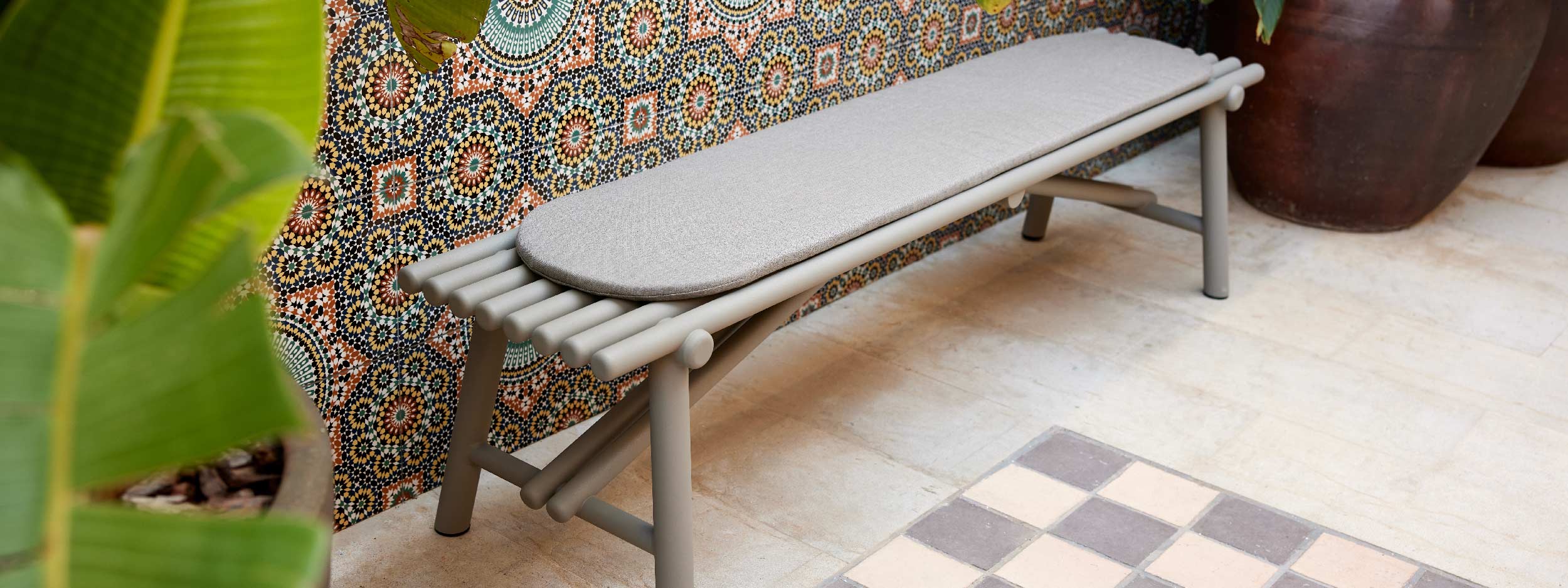 Image of Sticks garden bench seat and snug cushion with colourful Moroccan-inspired tiles in the background