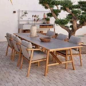 Image of Sticks teak table with ceramic top and Sticks dining chairs, with Sticks modular garden kitchen in the background