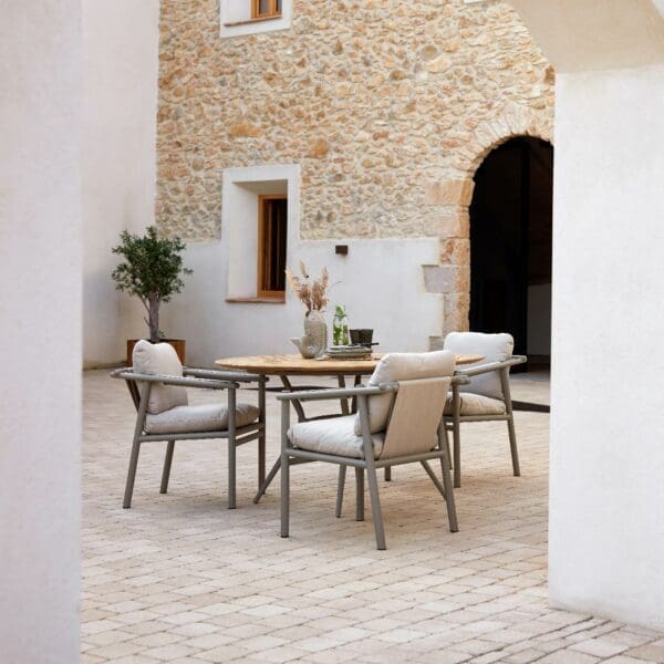 Image of Sticks garden armchairs around Joy contemporary dining table, in secluded rustic courtyard