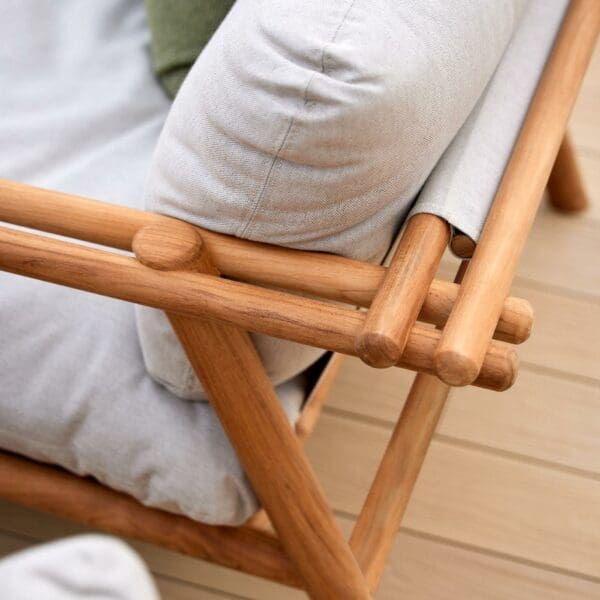 Image of detail of Sticks lounge furniture's circular teak profiles and plump Sand coloured cushions
