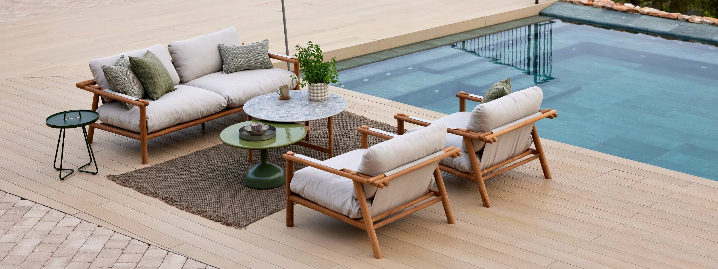 Image of Sticks FSC teak garden sofa and lounge chairs alongside swimming pool