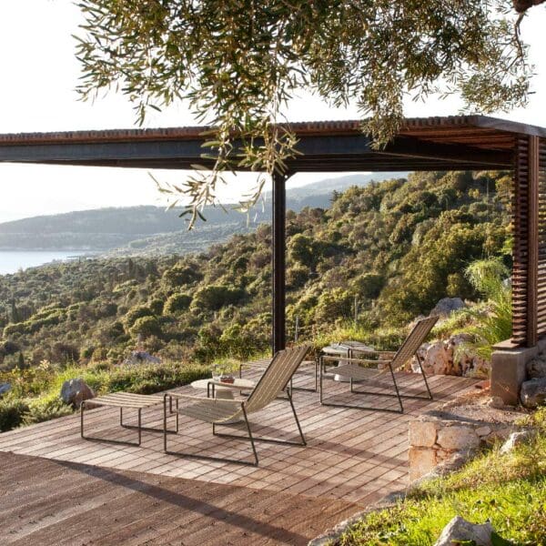 Image of pair of Strappy high-back garden lounge chairs beneath pergola on deck, overlooking countryside and coastline