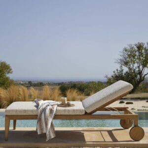 Image of Zenhit teak sunbed with chunky cream coloured cushion next to an inviting swimming pool on a hot & sunny day