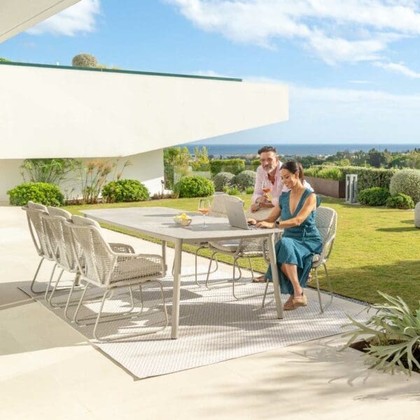 Image of Durham ceramic garden dining table and Alden taupe outdoor chairs on sunny terrace
