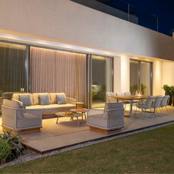 Nighttime image of Acri contemporary garden sofa and lounge chair on illuminated terrace